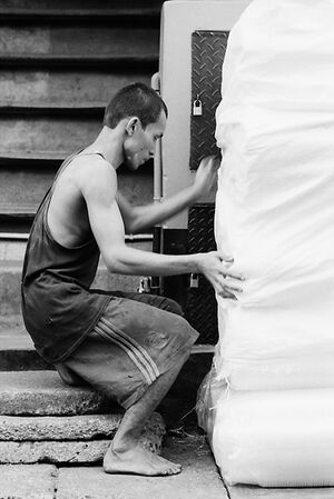 大きな荷を担ごうとする男