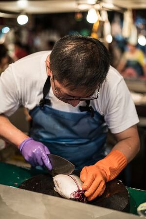 魚を捌く魚屋の男