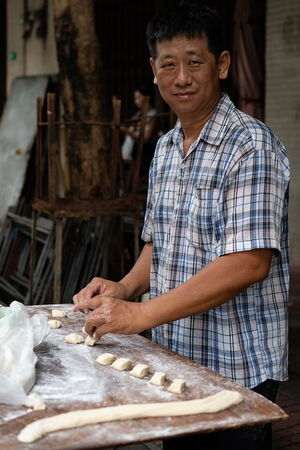 Man cutting stretched dough