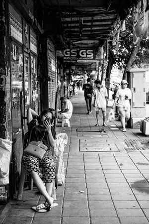 Woman leaning back on sidewalk