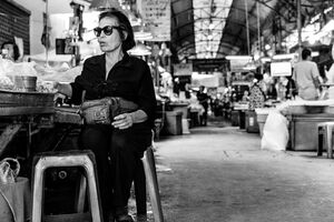 Shade-wearing woman in market
