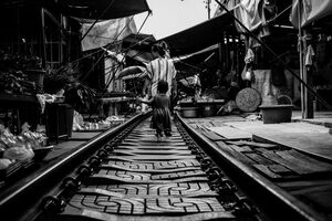 Mother and daughter walking on railroad