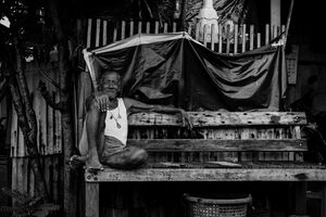 Old man sitting on wooden bench