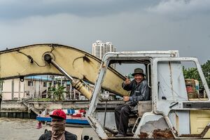 ショベルカーの運転席で親指を立てた男
