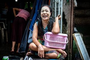 Woman beaking up laugh with white face