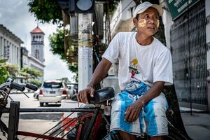 Pedicab driver waiting for customers in a street corner