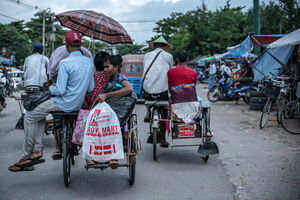 Pedicabs running street with passengers