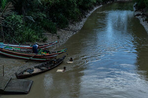 Wooden boats and two swimming boys
