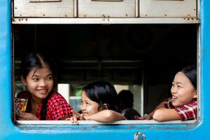Three girls sitting by car window