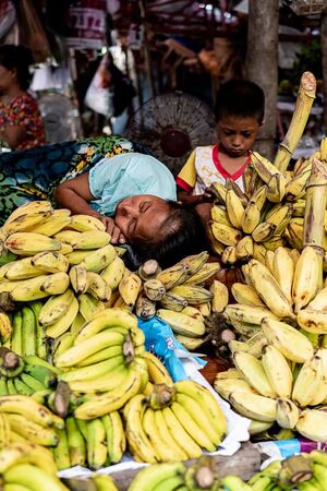 Mother sleeping on the other side of the pile of bananas