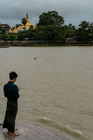 Man throwing offerings into river