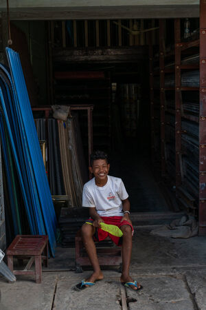 Boy sitting in storefront with a smile