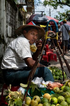Fruit seller with expression of boredom