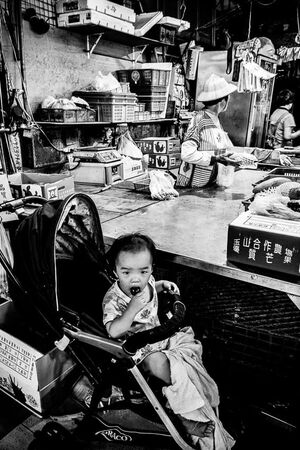 Baby on baby buggy in Chenggong Market