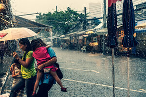 Family walking in heavy rain