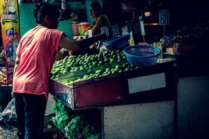 Woman browsing oranges in Khlong Toei Market