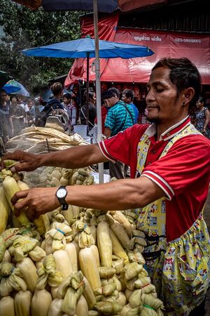 Man selling steamed corns in Khlong Toei Market