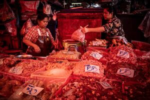 Two women working together in a butcher in Khlong Toei Market