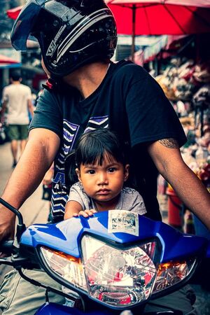 Little girl riding a motorbike with her father
