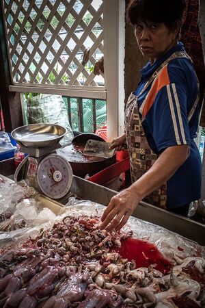 Woman selling frogs in Khlong Toei Market