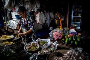 woman cutting bamboo sprouts in Maeklong Railway Market
