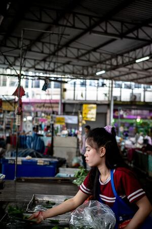 Young woman working in the market in Mae Klong