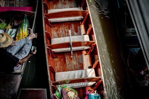 ボートの上でお金を見せる男