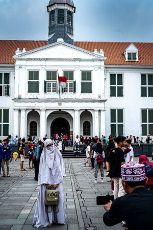 Young man taking a photo of his girlfriend in Fatahillah Square
