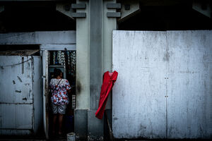 ジャカルタの町角の壁にかかる赤いワンピース