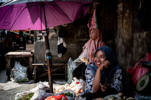 グロドック地区の八百屋で働くヒジャブをかぶった女性