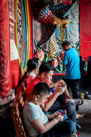 Young men playing a phone game in Jin De Yuan