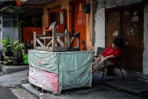 Older woman sleeping soundly in front of a closed shop