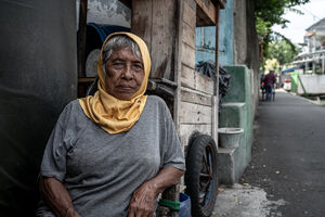 Older woman relaxing by the wayside in Jakarta