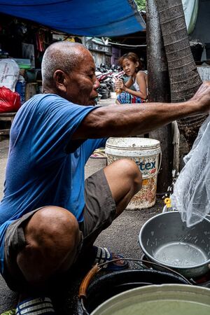 Old man washing up buckets