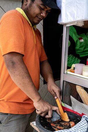 Man crushing spices in mortar