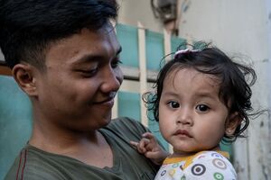 Father and his little daughter in the lane of Jakarta