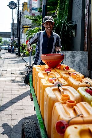 Man carrying polyethylene tanks