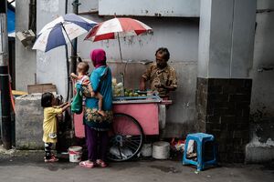 Parent and children shopping at a fruit stall