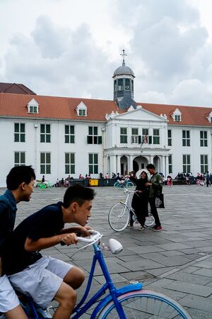 Couple taking a selfie and a bicycle in Fatahillah Square