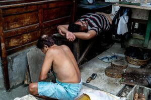 Man squatting and man lying down