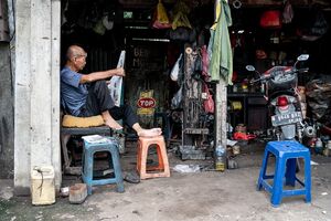 Man reading a newspaper in a maintenance shop