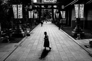 Old woman crossing the approach to Tomioka Hachimangu Shrine