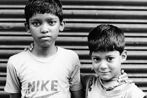 Two boys standing in front of shutter