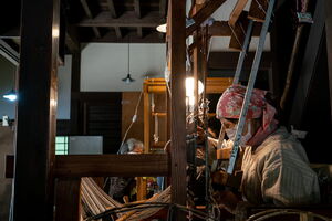 Woman weaving in an old house