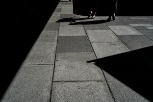 影と影の間を歩く女性の脚