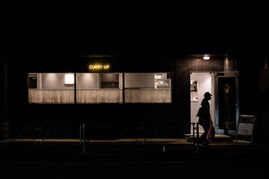 CURRY UP sign glowing in the dimly lit street
