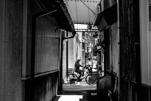 路地の先を横切る自転車