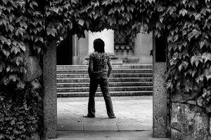 young man and ivy-covered gate
