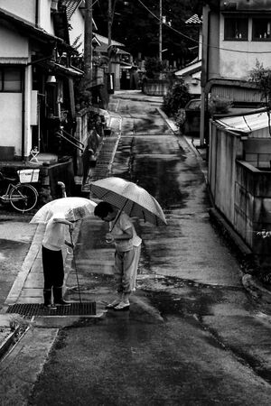 Two women standing in rain