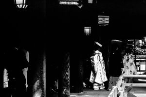 Bride walking the dark cloister in Meiji Jingu